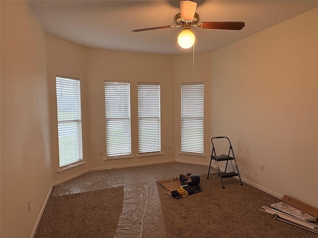 workout room with baseboards, a ceiling fan, and carpet flooring