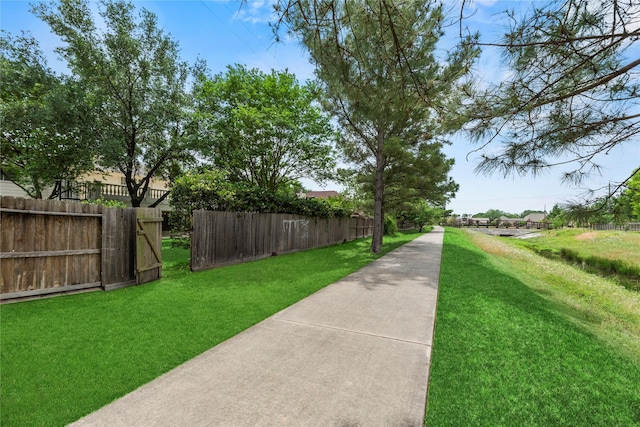 view of property's community featuring fence and a lawn