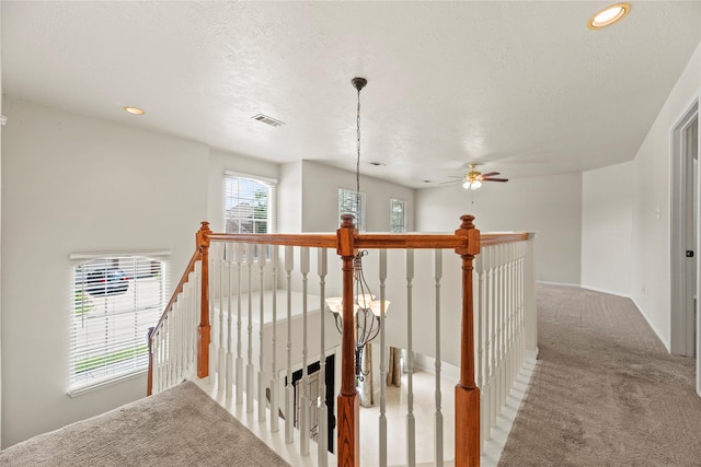 hall featuring an upstairs landing, visible vents, baseboards, recessed lighting, and carpet