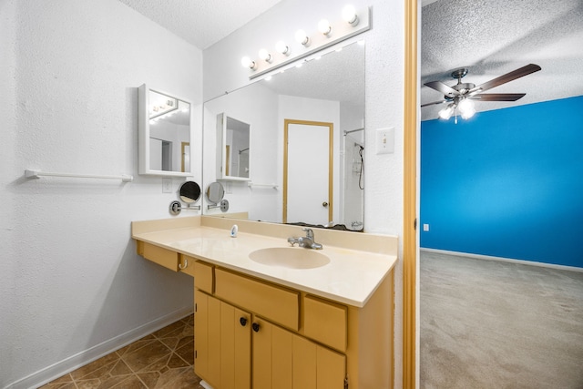 bathroom featuring baseboards, a textured ceiling, vanity, and ceiling fan