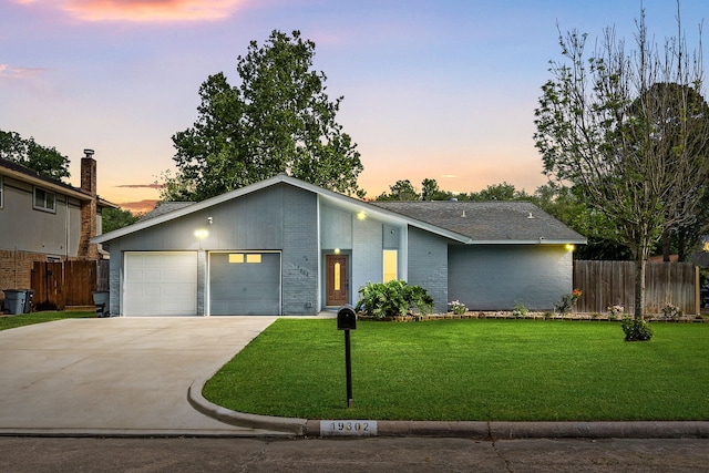 mid-century home featuring fence, driveway, and a front yard