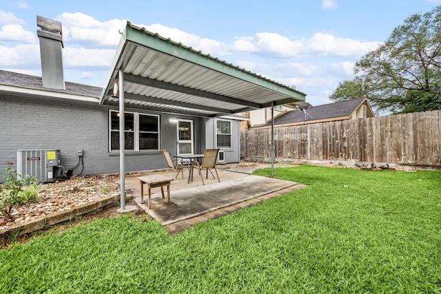 back of property with central AC unit, a chimney, fence, brick siding, and a lawn