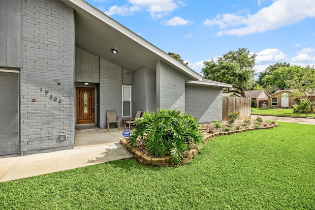 19302 Peach Valley Cir, Houston, TX 77084 - view of side of property with brick siding, a lawn, and a garage