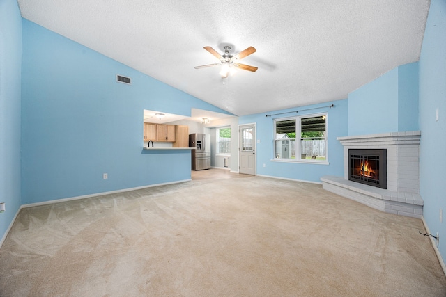 19302 Peach Valley Cir, Houston, TX 77084 - unfurnished living room with ceiling fan, a textured ceiling, light colored carpet, baseboards, and a brick fireplace