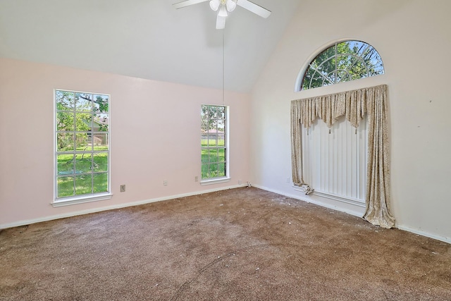 spare room featuring carpet, a healthy amount of sunlight, and high vaulted ceiling