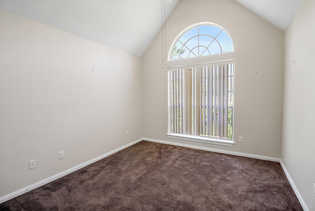 carpeted spare room with baseboards and high vaulted ceiling