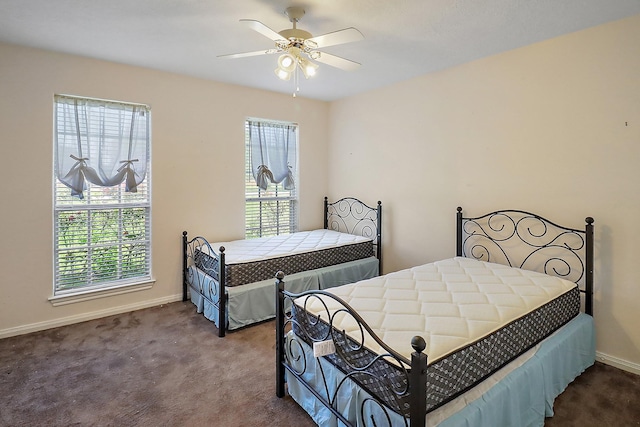 bedroom with ceiling fan, carpet floors, baseboards, and multiple windows