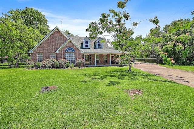 view of front of home with concrete driveway, a porch, brick siding, and a front lawn