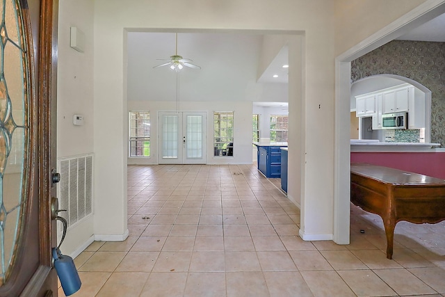 entryway with baseboards, visible vents, light tile patterned floors, and ceiling fan
