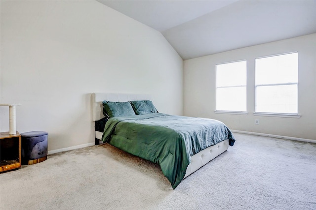 carpeted bedroom featuring baseboards and vaulted ceiling