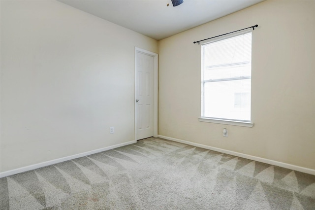 carpeted empty room with baseboards and ceiling fan