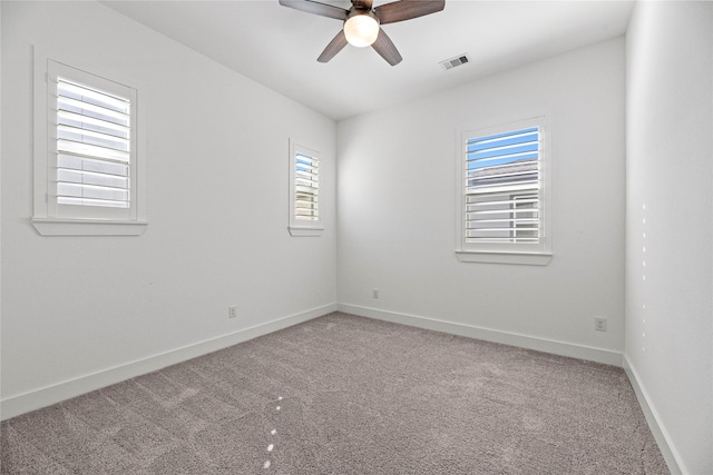 unfurnished room featuring ceiling fan, carpet floors, a healthy amount of sunlight, and visible vents