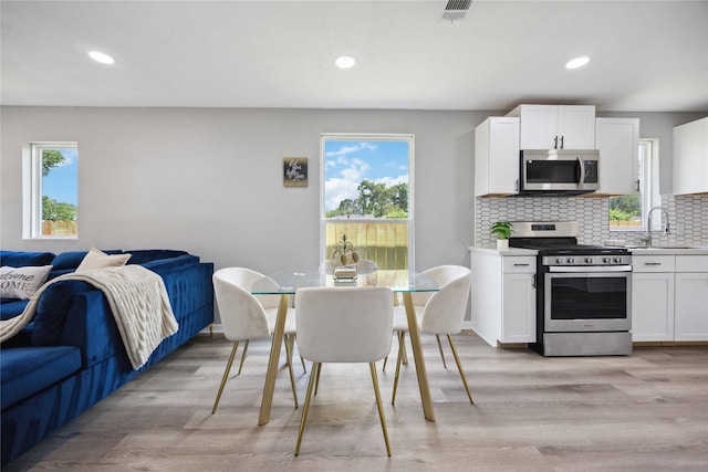 6810 Cohn St, Houston, TX 77091 - kitchen with visible vents, a sink, decorative backsplash, appliances with stainless steel finishes, and open floor plan