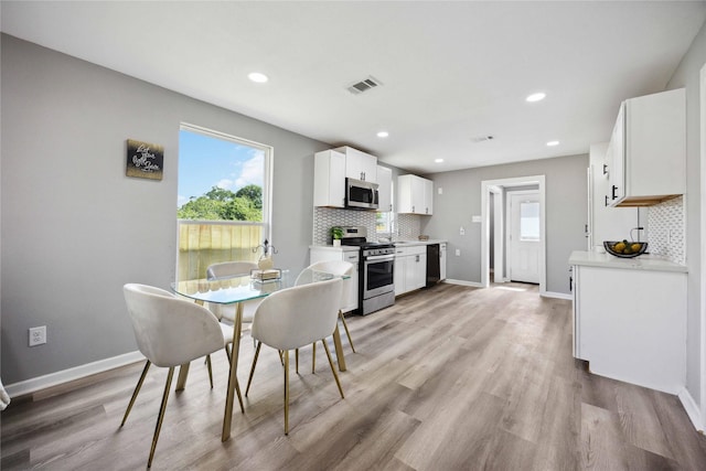 6810 Cohn St, Houston, TX 77091 - dining area with light wood-style floors, visible vents, and baseboards
