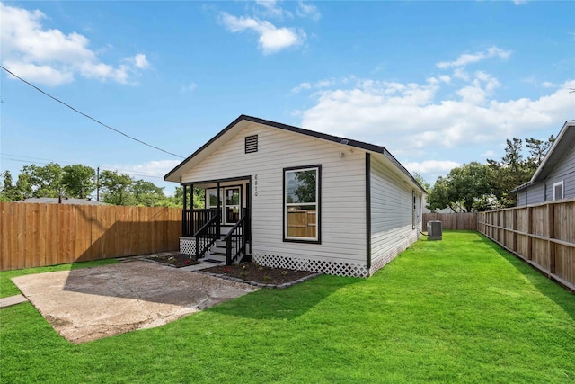6810 Cohn St, Houston, TX 77091 - rear view of house with a fenced backyard, entry steps, central air condition unit, a patio, and a lawn