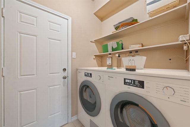 clothes washing area featuring independent washer and dryer, light tile patterned flooring, laundry area, baseboards, and an AC wall unit