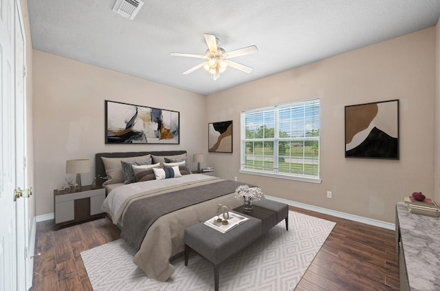 bedroom featuring visible vents, dark wood-style floors, and baseboards