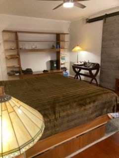 bedroom with wood finished floors and a barn door