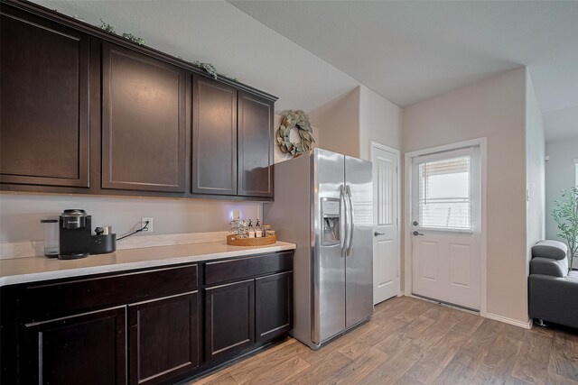 515 Green Clover Ln, Rosharon, TX 77583 - kitchen featuring light countertops, dark brown cabinets, light wood-type flooring, and stainless steel fridge with ice dispenser