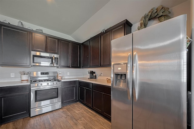 515 Green Clover Ln, Rosharon, TX 77583 - kitchen with lofted ceiling, light countertops, dark brown cabinetry, light wood-style flooring, and appliances with stainless steel finishes