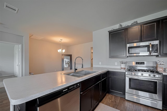 515 Green Clover Ln, Rosharon, TX 77583 - kitchen featuring a sink, stainless steel appliances, a peninsula, a notable chandelier, and visible vents