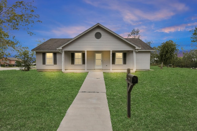 view of front of home with a porch, a shingled roof, and a front lawn