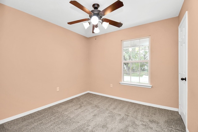 carpeted empty room featuring baseboards and ceiling fan