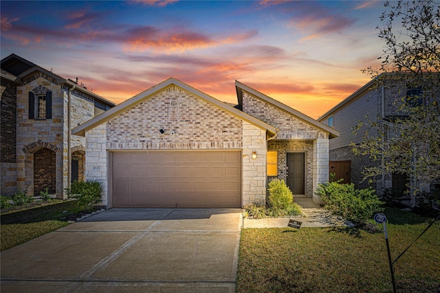 french provincial home with an attached garage, stone siding, and driveway