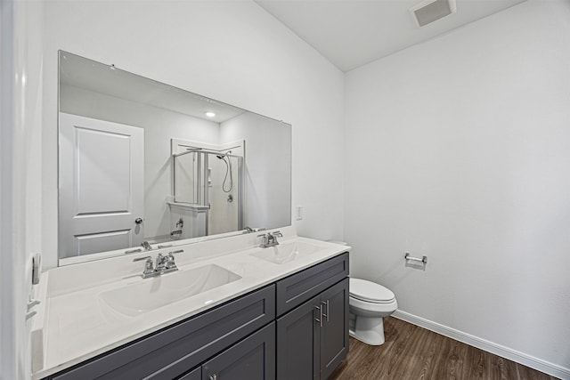 bathroom featuring wood finished floors, visible vents, baseboards, and a sink