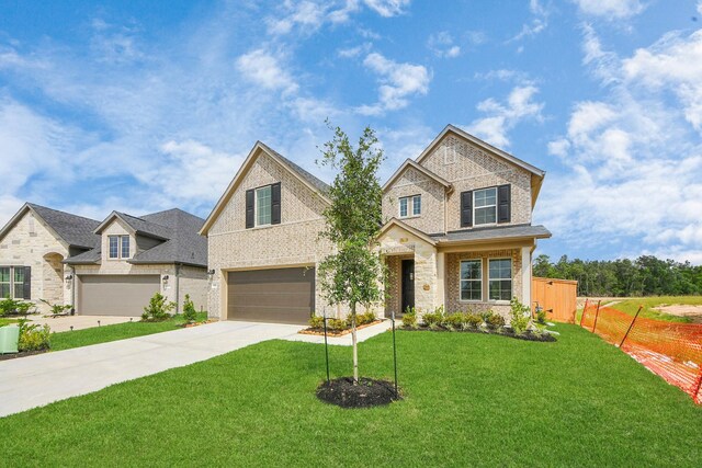 15607 Boulder Lake Ln, Conroe, TX 77302 - view of front facade with fence, stone siding, concrete driveway, a garage, and a front lawn
