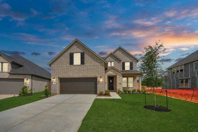 15607 Boulder Lake Ln, Conroe, TX 77302 - traditional-style home featuring a front lawn, driveway, brick siding, and a garage