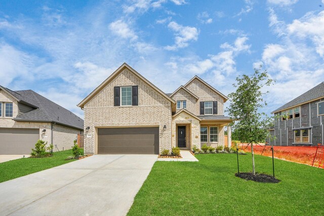 15607 Boulder Lake Ln, Conroe, TX 77302 - view of front of property featuring a front yard, brick siding, driveway, and a garage