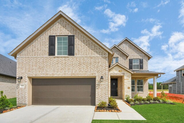 15607 Boulder Lake Ln, Conroe, TX 77302 - view of front of property featuring concrete driveway, an attached garage, a front lawn, and brick siding