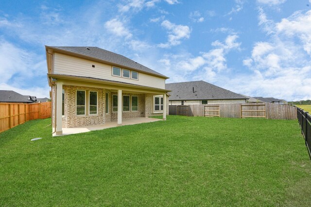 15607 Boulder Lake Ln, Conroe, TX 77302 - rear view of house with a yard, brick siding, a patio area, and a fenced backyard