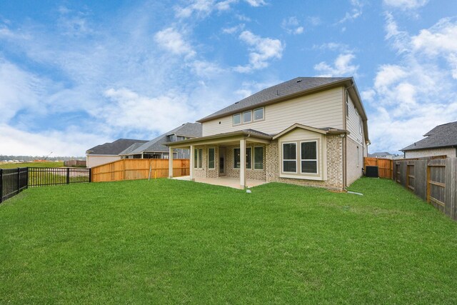 15607 Boulder Lake Ln, Conroe, TX 77302 - back of house with a yard, brick siding, a fenced backyard, and a patio area