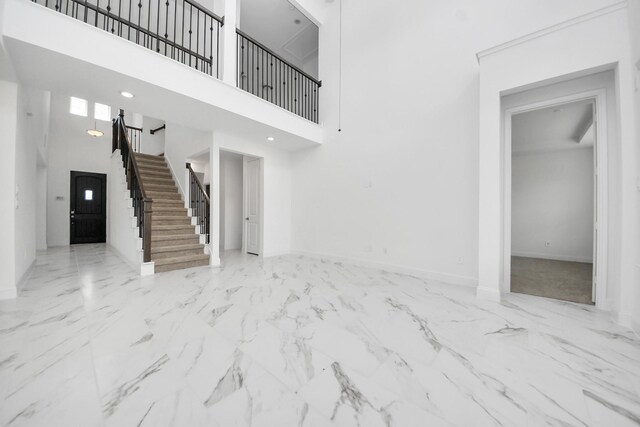 15607 Boulder Lake Ln, Conroe, TX 77302 - unfurnished living room featuring stairway, a high ceiling, baseboards, and marble finish floor