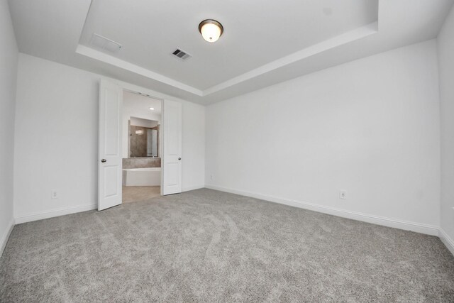 15607 Boulder Lake Ln, Conroe, TX 77302 - unfurnished bedroom featuring a tray ceiling, carpet, visible vents, and baseboards