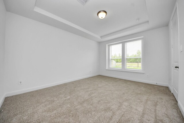 15607 Boulder Lake Ln, Conroe, TX 77302 - empty room featuring a tray ceiling, carpet flooring, baseboards, and visible vents