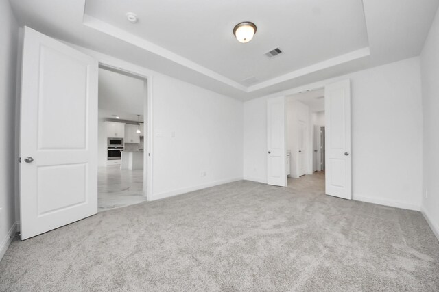 15607 Boulder Lake Ln, Conroe, TX 77302 - unfurnished bedroom with a tray ceiling, visible vents, and baseboards