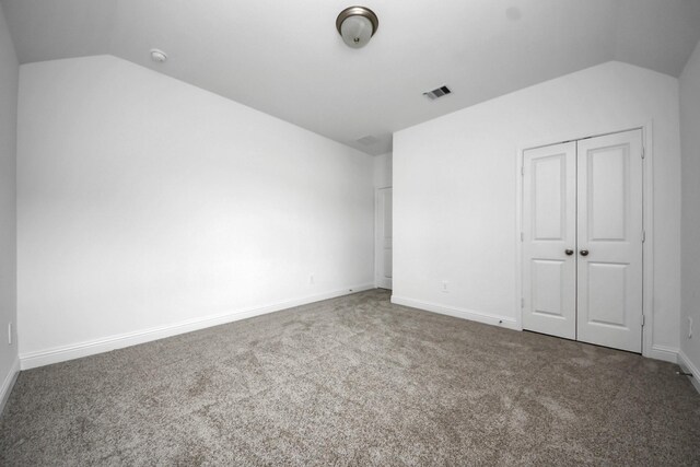15607 Boulder Lake Ln, Conroe, TX 77302 - unfurnished bedroom with lofted ceiling, carpet, baseboards, and visible vents