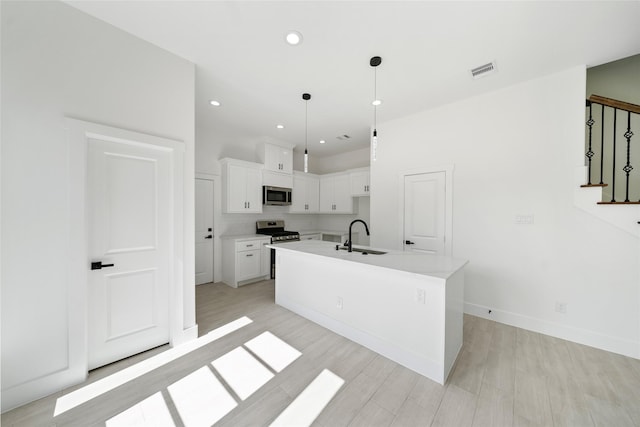 4519 Teton St, Houston, TX 77051 - kitchen with stainless steel appliances, a sink, a center island with sink, visible vents, and white cabinetry