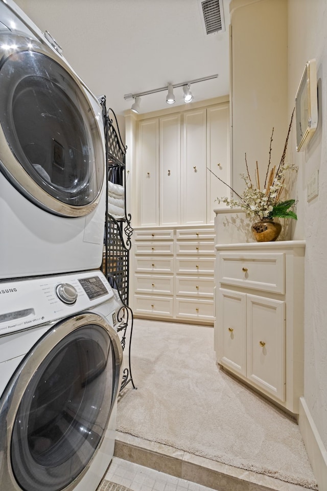 17511 Seidel Rd, Tomball, TX 77377 - washroom featuring visible vents, stacked washer / dryer, rail lighting, light colored carpet, and laundry area