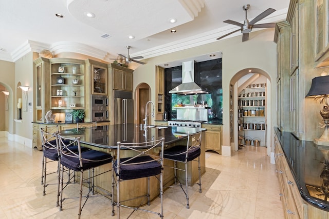 17511 Seidel Rd, Tomball, TX 77377 - kitchen featuring crown molding, ceiling fan, arched walkways, wall chimney exhaust hood, and appliances with stainless steel finishes