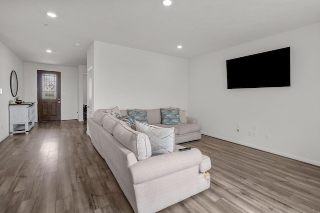 living room featuring recessed lighting, baseboards, and wood finished floors