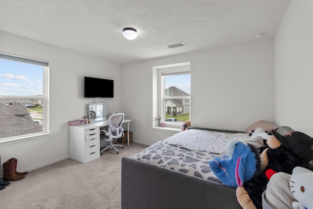 bedroom with a textured ceiling, baseboards, visible vents, and light carpet