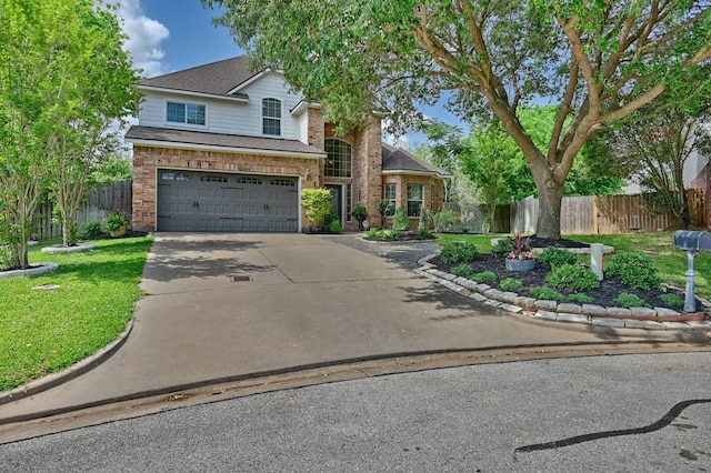 traditional-style house featuring concrete driveway, roof with shingles, fence, brick siding, and a garage
