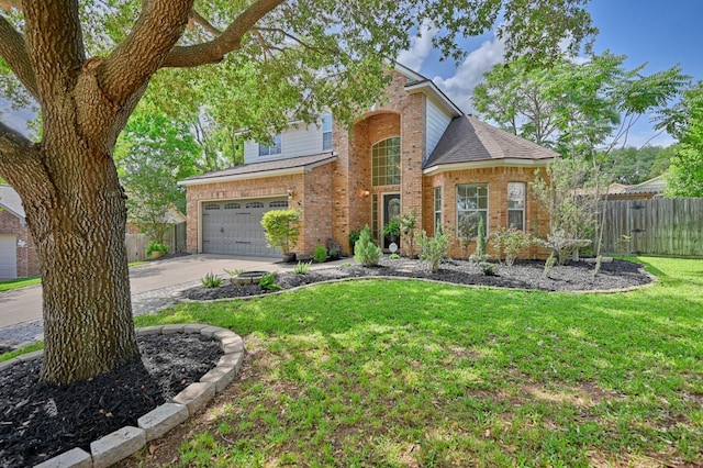 traditional home with brick siding, fence, a garage, a front lawn, and concrete driveway