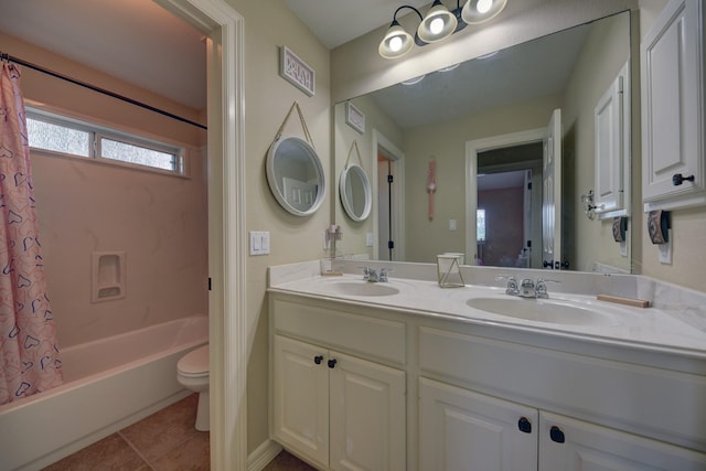 full bathroom with toilet, double vanity, a sink, and tile patterned flooring