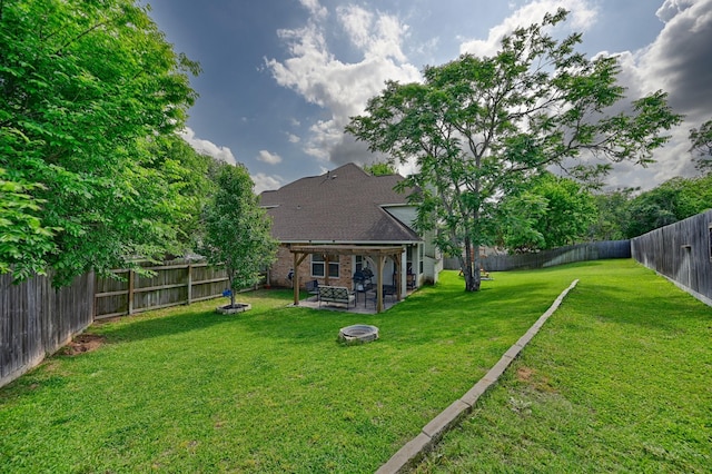 view of yard with a fire pit, a patio, and a fenced backyard