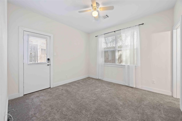 unfurnished room featuring visible vents, carpet flooring, and a wealth of natural light